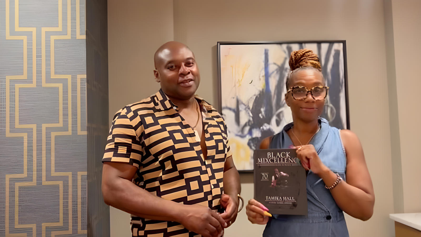 Tamika Hall holding her book, Black Mixcellence: A Comprehensive Guide to Black Mixology.